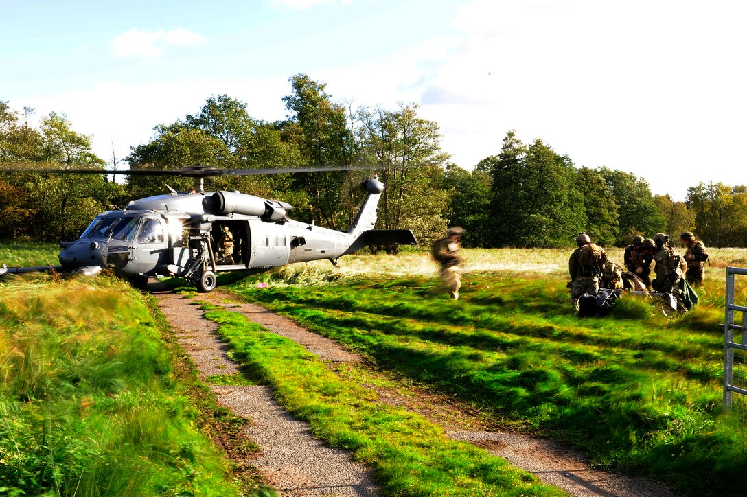 The crew of an HH-60G Pave Hawk helicopter stands by as pararescuemen assist wounded servicemembers during an exercise Oct. 20, 2010, at Stanford Training Area, England. The role of the 56th Rescue Squadron was to provide underwater recovery capability to British ground forces preparing to deploy to Afghanistan. Once the underwater recovery was complete, the 56th RQS also provided medical and casualty evacuation support. (U.S. Air Force photo/Airman 1st Class Lausanne Morgan)