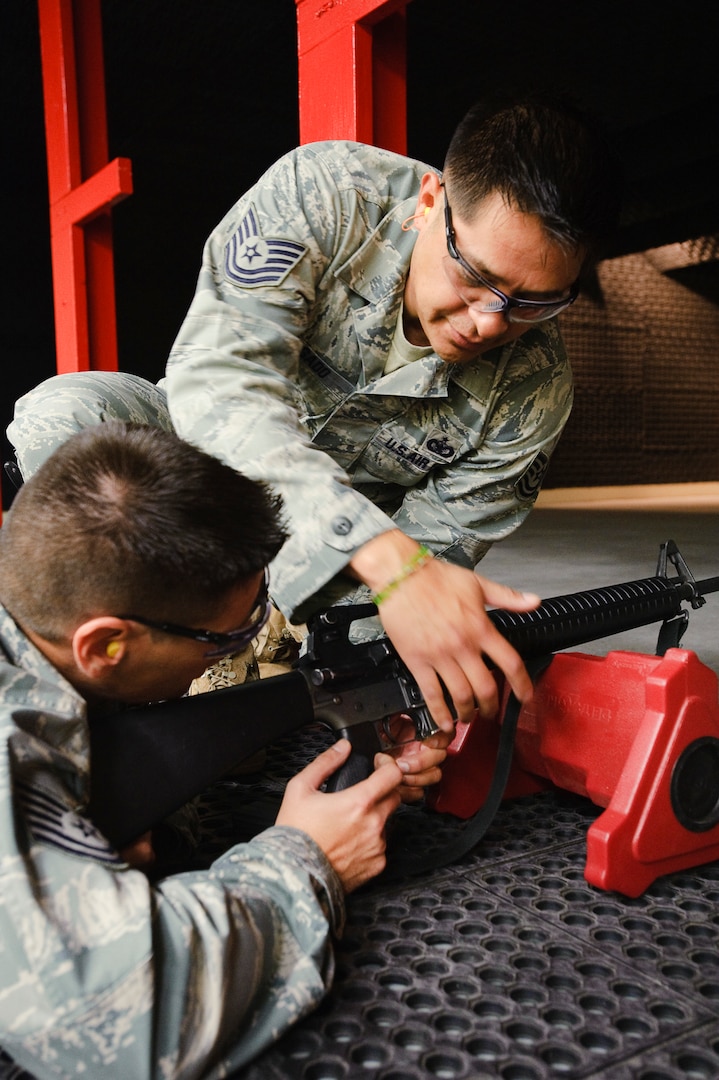 Randolph AFB, TX, 03 November 2010:  Tech. Sgt. Arturo Delgado, combat arms instructor with the 902nd Security Forces Squadron, assists a trainee with clearing a weapon jam during the first Air Force Qualification Course live fire training conducted at Randolph in two years. The reopening saves approximately 2.5 hours of traveling per firing class and alleviates scheduling conflicts and range closures at other facilities allowing the 902nd SFS the ability to conduct more effective training. 
(U.S. Air Force photo/Steve Thurow)