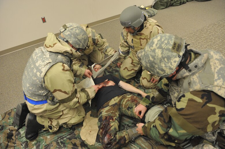 Airmen apply bandages and a tourniquet to a wounded Airman Nov. 2 during the 21st Space Wing’s Condor Crest exercise on Peterson Air Force Base. Airmen were tested on self aid buddy care, which requires all Airmen to know basic life support and limb-saving techniques to help wounded or injured personnel. In this scenario, Airmen were deployed to “Tereen, Afghanistan” for a chemical war event. The focus of the exercise was to prepare Airmen to deploy into a chemical environment. The wing’s ability to perform deployment operations is among the areas expected to be scrutinized during an upcoming Operational Readiness Inspection conducted by the Air Force Space Command Inspector General. (U.S. Air Force photo/Robb Lingley)