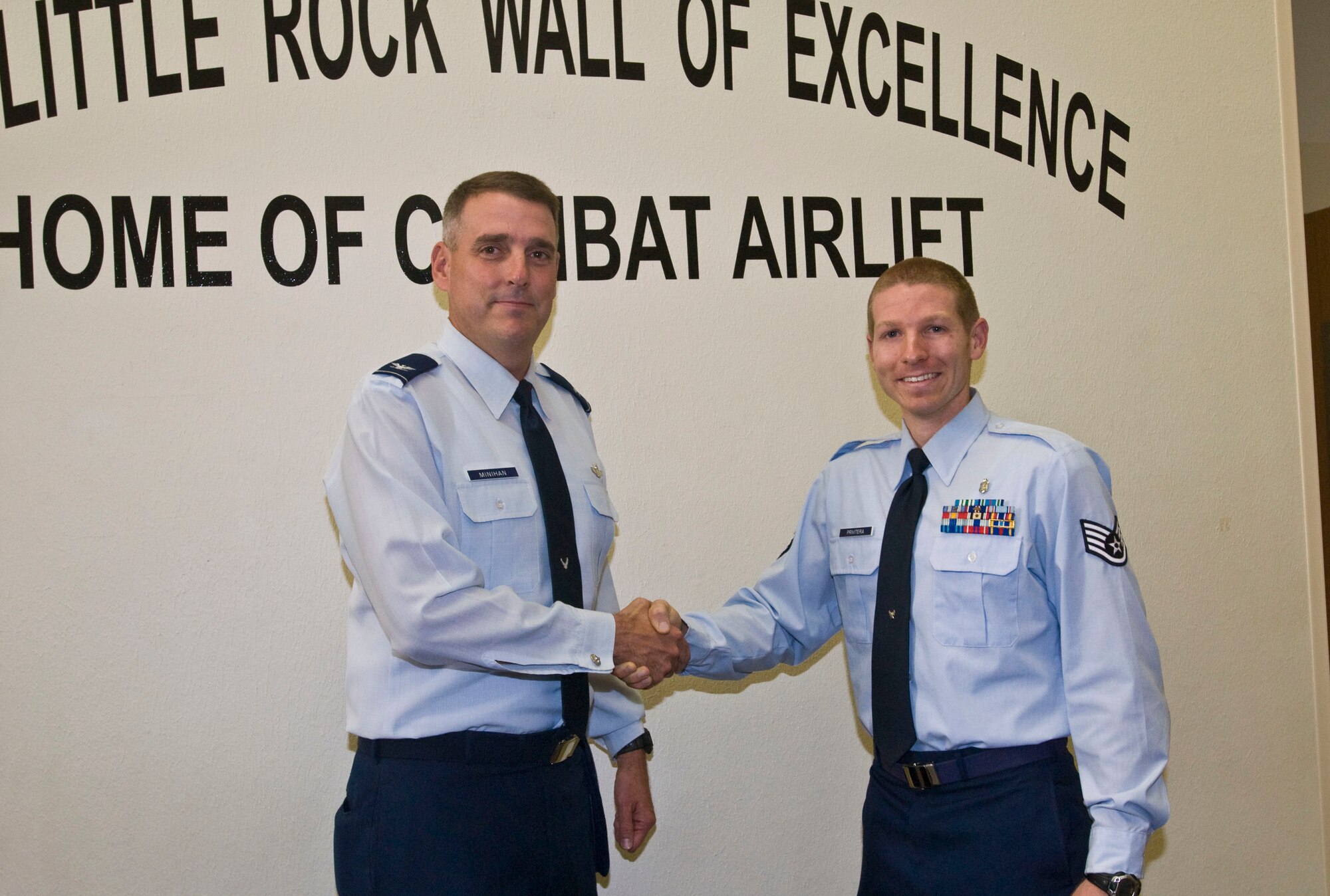 Col. Mike Minihan (left), 19th Airlift Wing commander, presents a coin Nov. 1 to Staff Sgt. Jason Privitera, 19th Aerospace Medicine Squadron Health and Wellness Center NCO-in-charge, for his selection as the Combat Airlifter of the Week. Sergeant Privitera reviews more than 300 medical records per month for fitness exemptions and fitness prescriptions, ensuring members receive the best fitness prescription within three days of notification. (U.S. Air Force photo by Staff Sgt. Nestor Cruz)