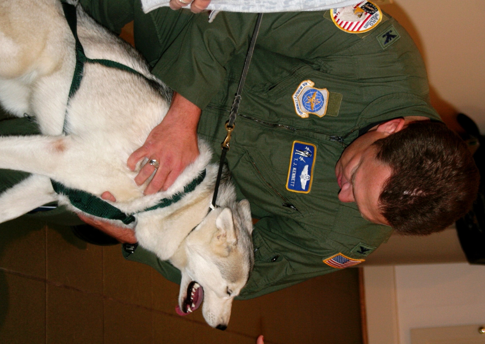 Col. Thomas Kennett, from Headquarters Air Mobility Command at Scott Air Force Base, Ill., greets a Siberian Husky named "Nomad" at the American Kennel Club Museum of the Dog in Saint Louis, Mo., on Nov. 2, 2010. Colonel Kennett was part of the audience for a presentation of an Antarctic airway chart created by Col. Ronald Smith -- also from AMC. The chart shows “Airway 338” waypoints with each waypoint named after sled dog teams of Norwegian explorer Roald Amundsen and the pony pack team of British explorer Capt. Robert Falcon Scott. The aeronautical chart is used in international flight navigation from New Zealand to Antarctica -- especially for Operation Deep Freeze. (U.S. Air Force Photo/Master Sgt. Scott T. Sturkol)