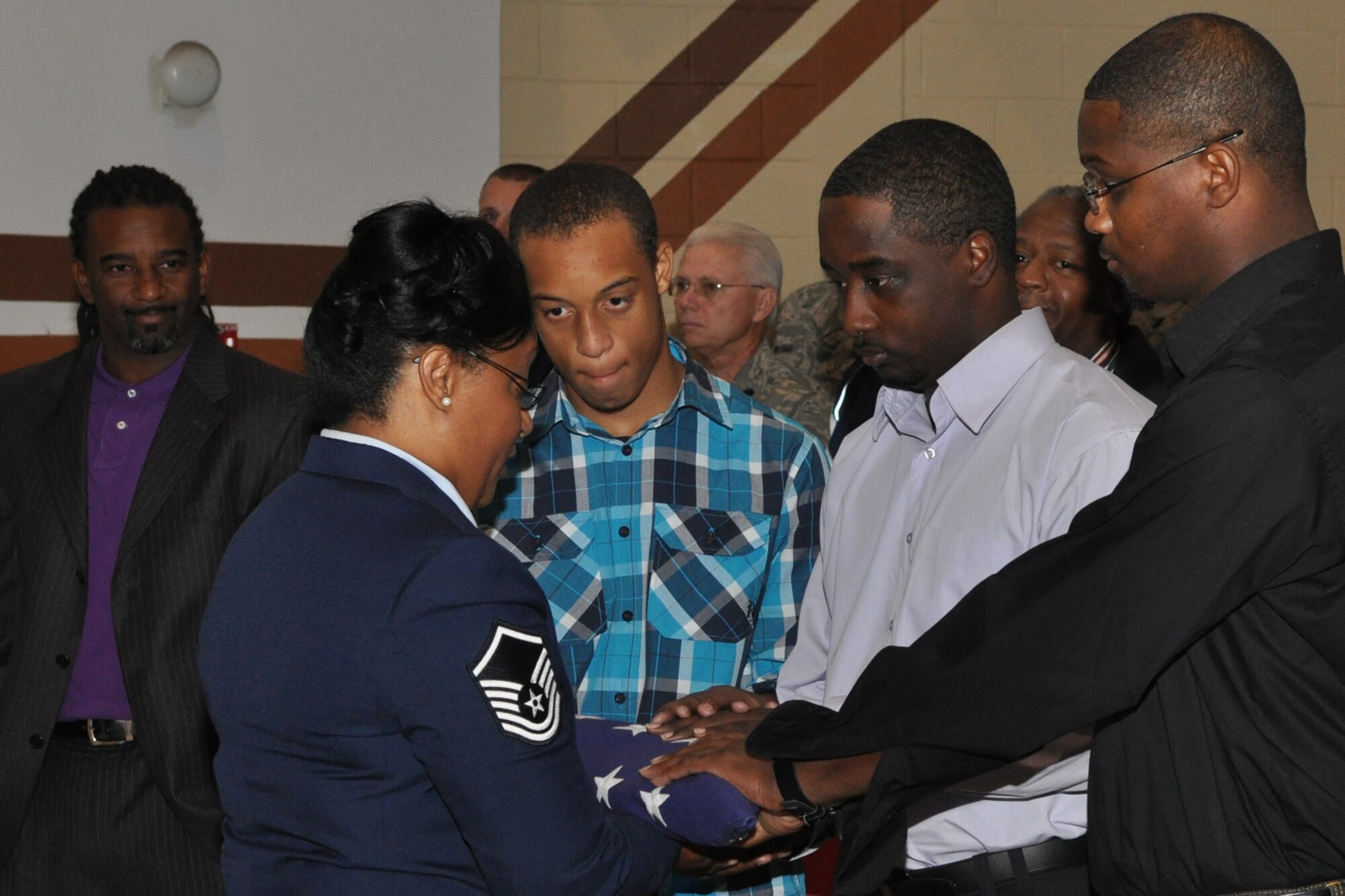 Master Sgt. (Ret) Aunshelle J. White presents an American Flag to her sons during an emotional retirement ceremony at Barksdale Air Force Base, La., Nov. 7, 2010. Sergeant White retired after 22 years of service with the 917th Wing. Many of Sergeant White’s family and friends filled the base theater at Barksdale for the ceremony. (U.S. Air Force photo/Tech. Sgt. Jeff Walston)    