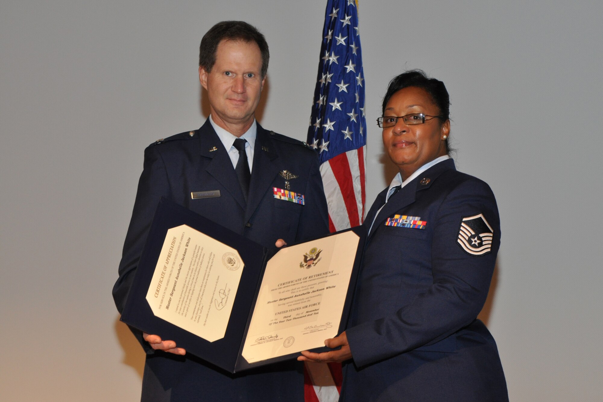 Master Sgt. (Ret) Aunshelle J. White poses with Col. Dean E. Robinson, commander, 917th Medical Squadron during an emotional retirement ceremony at Barksdale Air Force Base, La., Nov. 7, 2010. Sergeant White retired after 22 years of service with the 917th Wing. Many of Sergeant White’s family and friends filled the base theater for the ceremony, during which she presented an America Flag to her three sons. (U.S. Air Force photo/Tech. Sgt. Jeff Walston)    