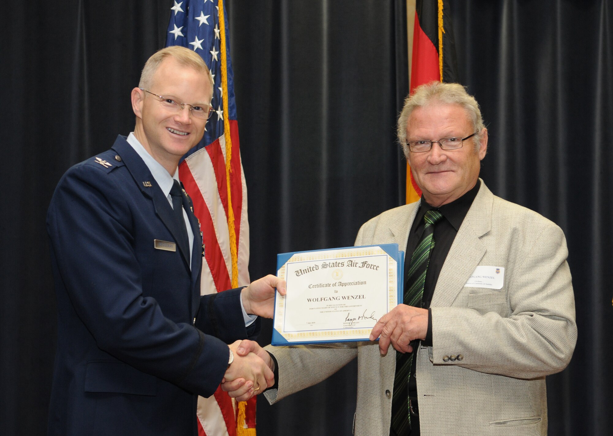 SPANGDAHLEM AIR BASE, Germany – Col. Christopher Weggeman, 52nd Fighter Wing commander, presents Mr. Wolfgang Wenzel, 52nd Civil Engineer Flight housing and appliances electrical technician, a certificate Nov. 5 in recognition of 45 years of service to the U.S. government. Mr. Wenzel has been working as an electrician at the Bitburg and Spangdahlem Air Bases since July 1965. (U.S. Air Force photo/Staff Sgt. Benjamin Wilson)