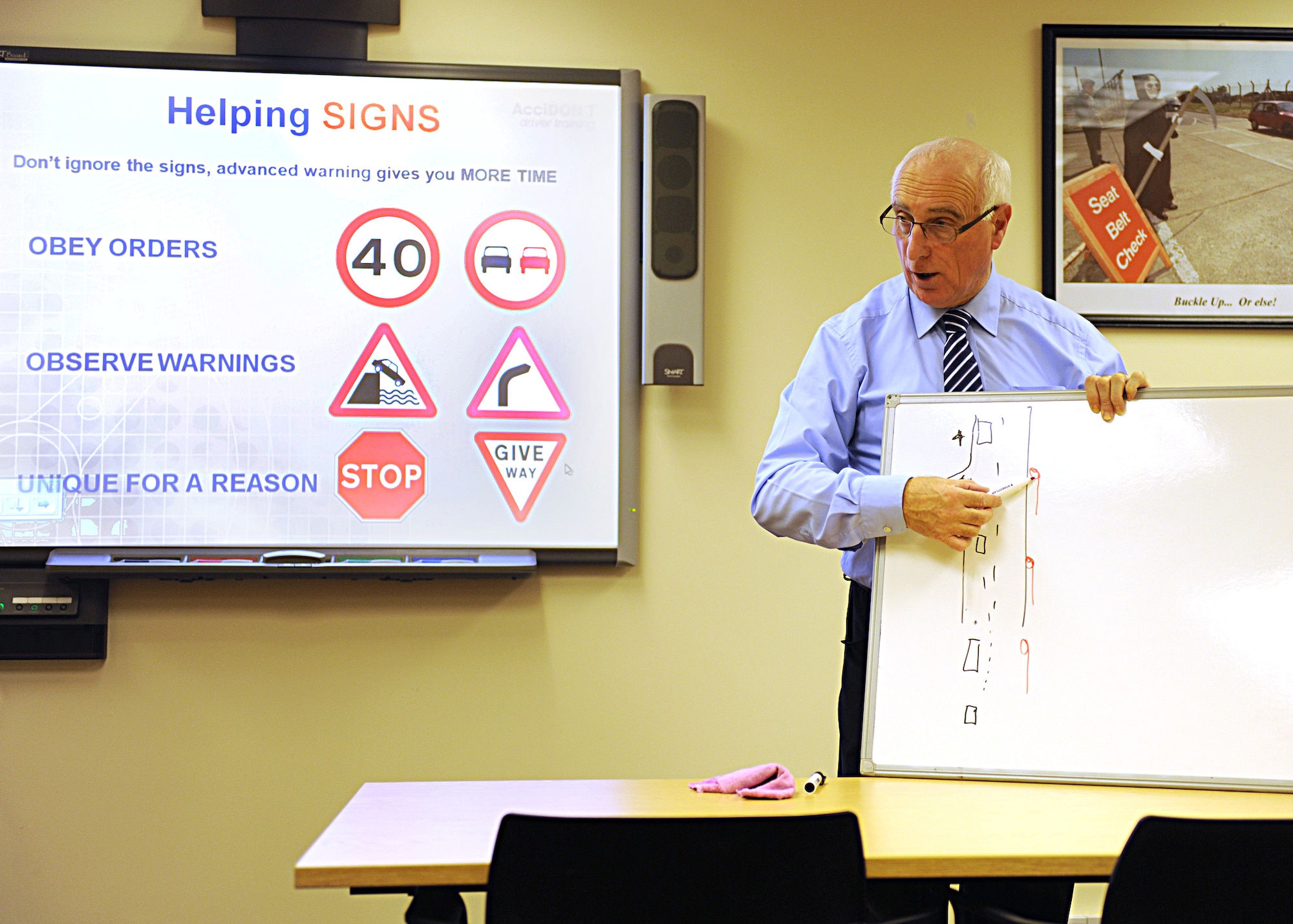 RAF MILDENHALL, England -- Mike Daniels, AcciDON'T advanced driving trainer, draws scenarios on a white board during the AcciDON'T driving course offered by the 100th Air Refueling Wing Safety Office here Nov. 5, 2010.  This course is offered to familiarize visiting forces members with United Kingdom driving conditions.  (U.S. Air Force photo/Senior Airman Tabitha M. Lee)