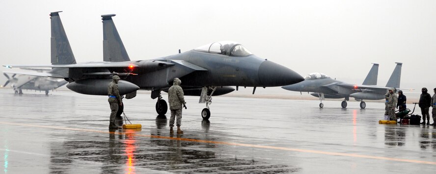 Members of the 44th Aircraft Maintenance Unit prepare to ‘safe’ the F-15 Eagle of Lt. Col. Joel Carey, 44th FS Commander, foreground, as he taxis to park on the ramp on a rainy day at Chitose Defense Base, Hokkaido Prefecture, Japan. The arrival of six F-15s today officially started the two-week Kadena Aircraft Training Relocation to Chitose Air Base. A total of 12 jets are scheduled to arrive and about 180 Airmen are here to support the ATR. (U.S. Air Force photo/Tech. Sgt. Mike Tateishi