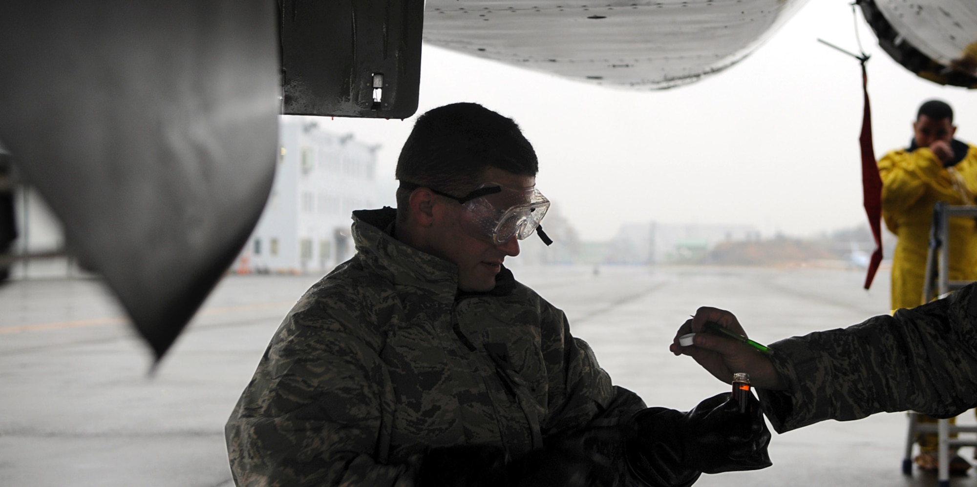 Staff Sgt. Arthur Branham, 44th Aircraft Maintenance Unit, collects oil from a recently arrived F-15 at Chitose Air Base, Hokkaido Prefecture, Japan. The oil is sent to the National Defense Institute for analysis as part of the Joint Oil Analysis Program. The oil is checked after the first flight of each day’s sorties. (U.S. Air Force photo by Tech. Sgt. Mike Tateishi)