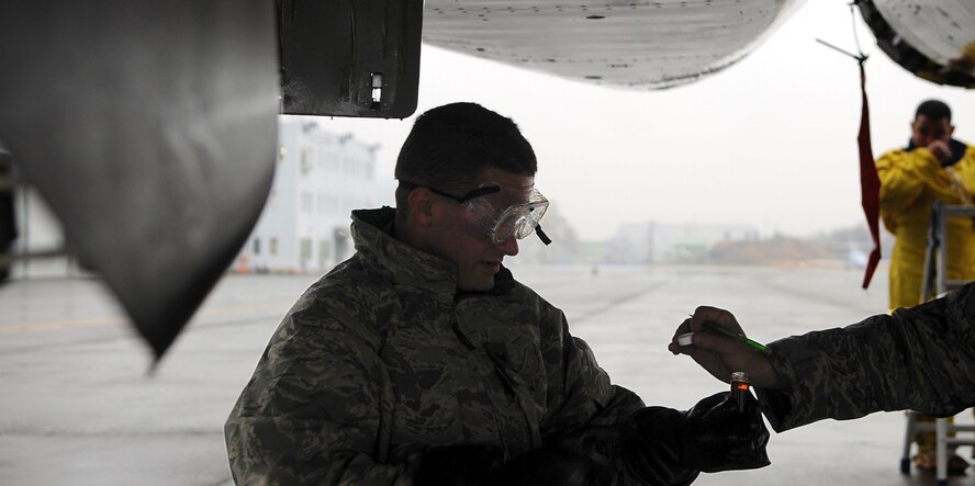 Staff Sgt. Arthur Branham, 44th Aircraft Maintenance Unit, collects oil from a recently arrived F-15 at Chitose Air Base, Hokkaido Prefecture, Japan. The oil is sent to the National Defense Institute for analysis as part of the Joint Oil Analysis Program. The oil is checked after the first flight of each day’s sorties. (U.S. Air Force photo by Tech. Sgt. Mike Tateishi)