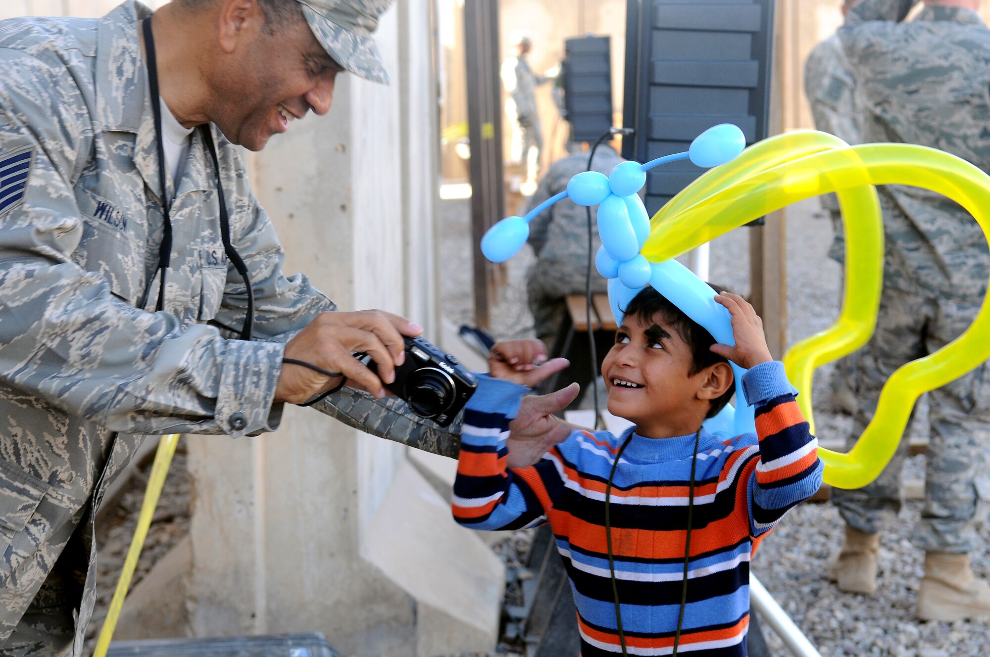Tech. Sgt. William Wilson, 332nd Expeditionary Logistics Readiness Squadron hazardous cargo technician shows an Iraqi child a photo on his camera during Iraqi Kids Day Nov. 6, 2010, Joint Base Balad, Iraq. “We are trying to provide a safe structured environment for the kids to interact with U.S. personnel,” said Capt Daniel Coleman, 332nd Expeditionary Medical Group executive officer, Iraqi Kids Day program coordinator. (U.S. Air Force Photo/ Senior Airman Marianne E. Lane)