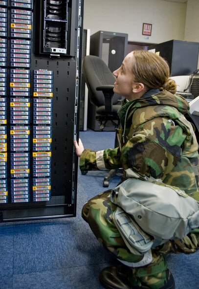 Senior Airman Courtney Cummings, 35th Communications Squadron configure management technician, performs maintenance on the squadron’s network control center backup tape drive, Nov. 8, 2010, at Misawa Air Base, Japan. Airman Cummings, donned in her mission oriented protective posture gear, participates in a wing-wide operational readiness exercise while executing her job. (U.S Air Force photo by Senior Airman Jessica Lockoski/Released)