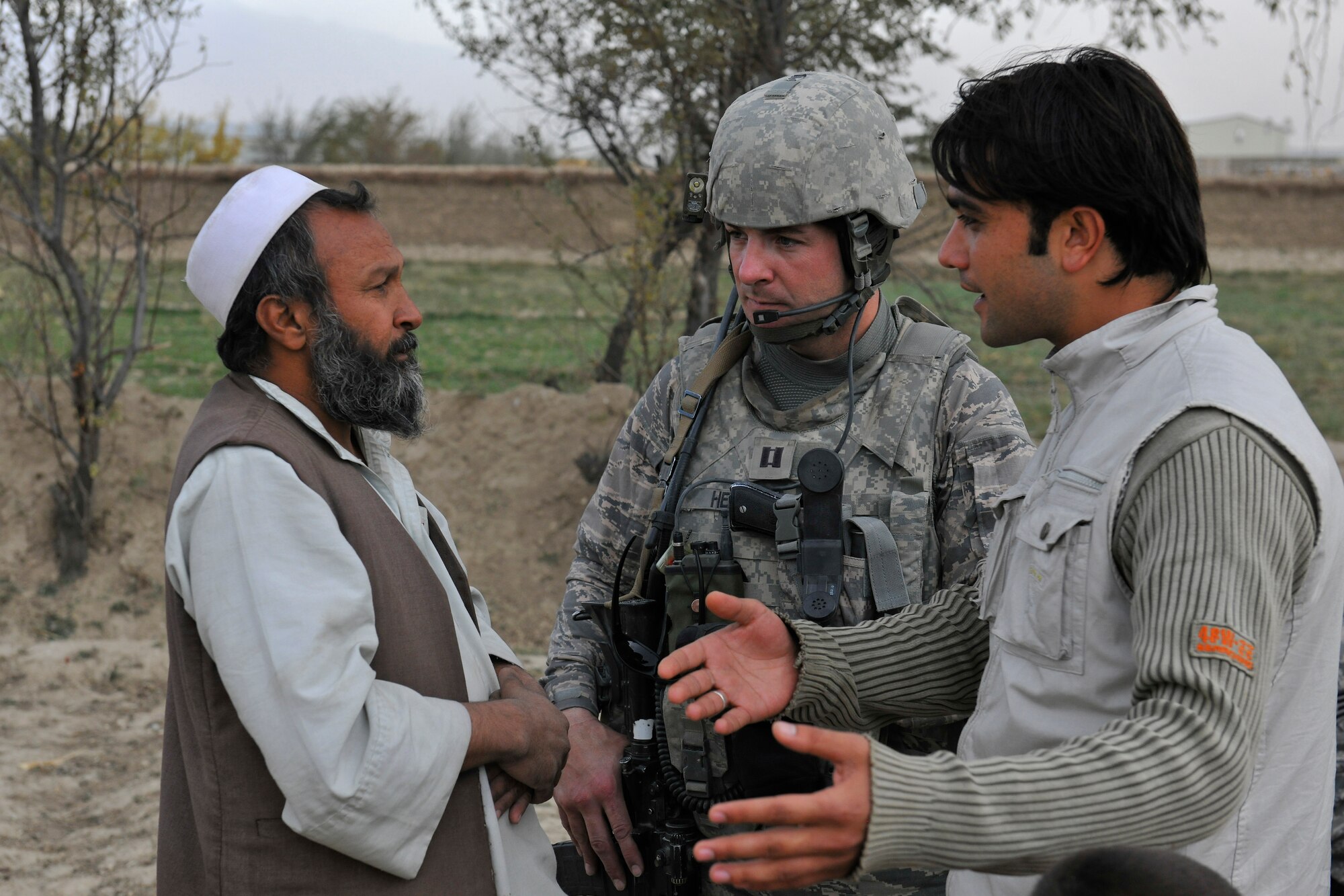 Capt. George Hern, a sector commander assigned to the 455th Expeditionary Security Forces, speaks with an Afghan farmer during a dismounted patrol near Bagram Airfield, Afghanistan, November 5, 2010. The Airmen were conducting presence patrols and visiting with Afghans. The Airmen presented the farmer and his children with a pair of gloves and bags of candy. (U.S. Air Force photo/Staff Sgt. Christopher Boitz)