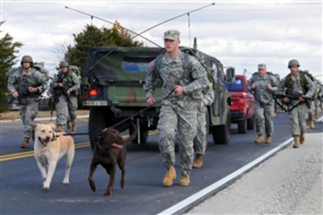 Army Staff. Sgt. Steven Caldwell, front, accompanied by his two canine friends Rugger and Reese, leads the pack for the 19 officer candidates in a 10-mile march also known as Reaper Ruck, on Camp Atterbury Joint Maneuver Training Center, Ind., Nov. 6, 2010. Caldwell is an instructor is assigned to the Officer Candidate School.