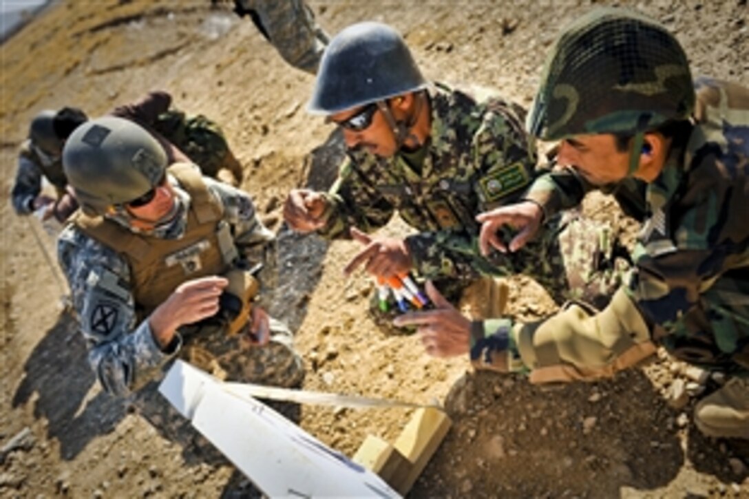 U.S. Army Sgt. 1st Class John Haidu listens as Afghan soldiers training to be instructors explain why their target grouping is off and how to correct it during a marksmanship course at Kabul Military Training Center, Afghanistan, Nov. 6, 2010. After the 10-day course, the soldiers will be able to instruct Afghan Naitonal Arny  trainees in basic marksmanship.