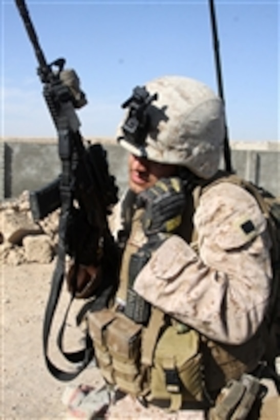 U.S. Marine Corps Sgt. Chris Bustamante, with Police Adviser Team 1, 3rd Battalion, 5th Marine Regiment, Regimental Combat Team 2, communicates with fellow Marines as they leave the northern checkpoint during a security patrol with Afghan Uniformed Police officers through the northern bazaar in Sangin, Afghanistan, on Nov. 1, 2010.  The battalion was one of the combat elements of Regimental Combat Team 2, whose mission was to conduct counterinsurgency operations with the International Security Assistance Force.  