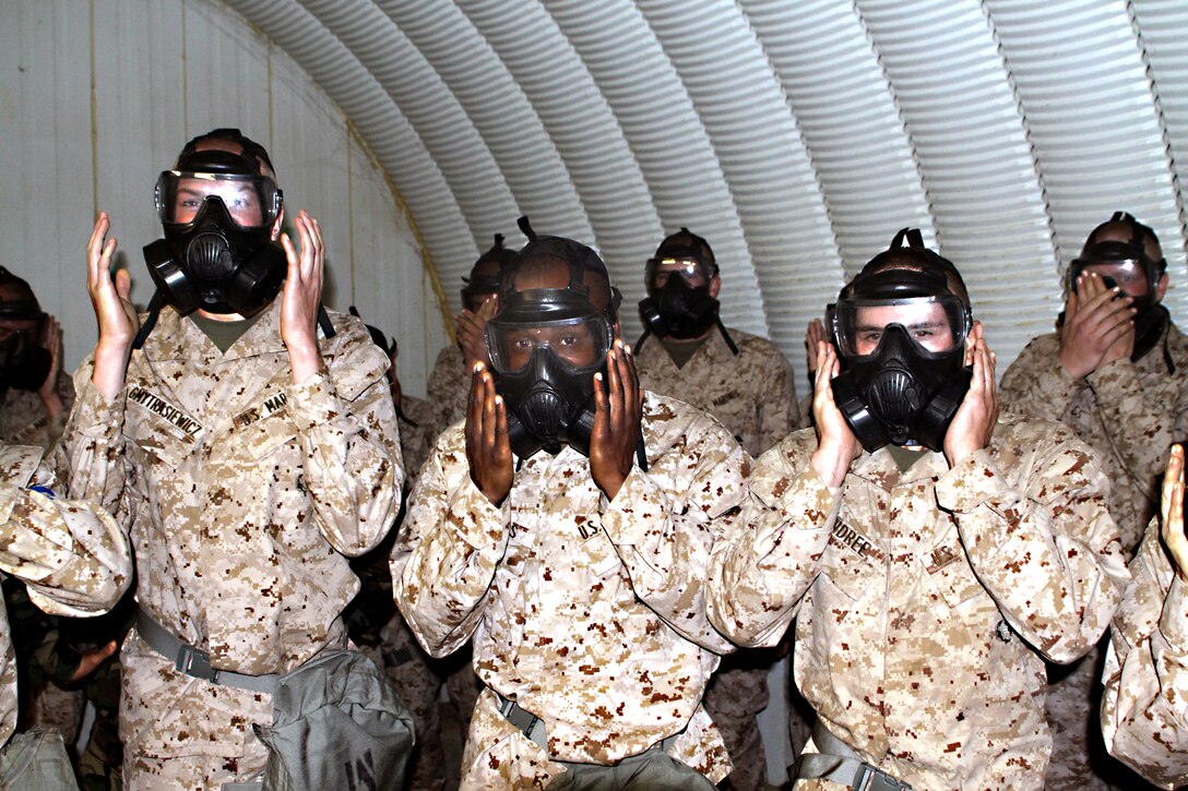 Recruits from Platoon 3266, Company M, 3rd Battalion, check their gas masks seals before being introduced to CS gas at the Confidence Chamber, at Weapons Field Training Battalion, Marine Corps Base Camp Pendleton, Calif. Nov. 8. The recruits clear their masks of any chemicals that may have entered and ensure that masks are properly sealed.