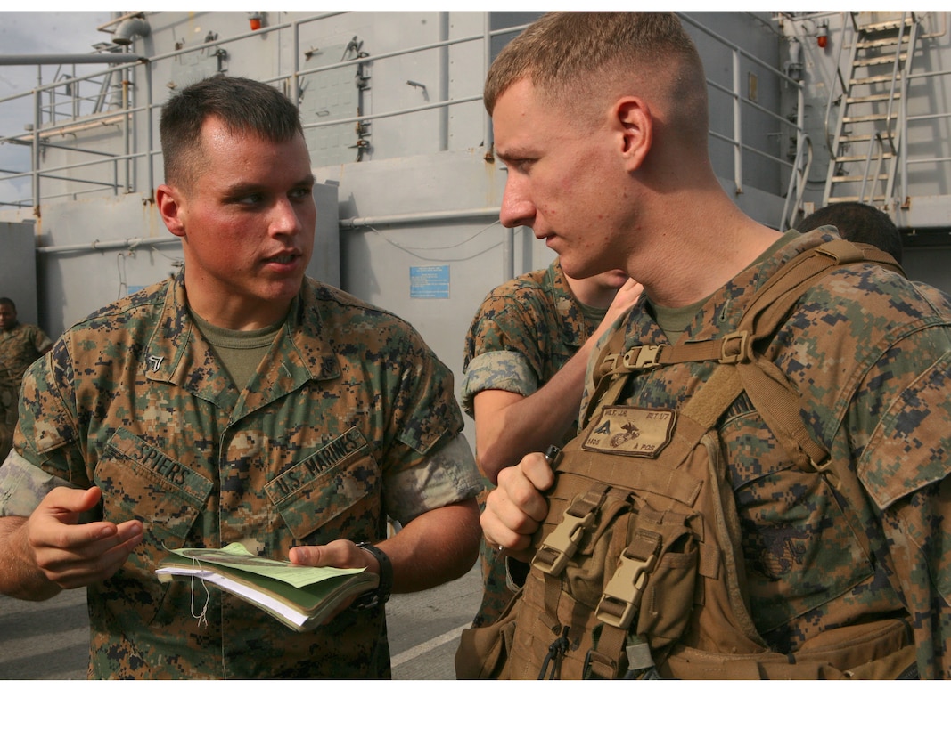 Cpl. Lance Spiers, fires chief with 5th Air Naval Gun Liaison Company, 31st Marine Expeditionary Unit,  and Lance Cpl. James Wilt, SAW gunner with Company A, Battalion Landing Team, 1st Battalion, 7th Marines, 31st MEU, go over enemy coordinates, during a simulated close air support exercise. The training is designed to help Marines, in a combat situation, talk with pilots and communicate necessary information to receive air support.