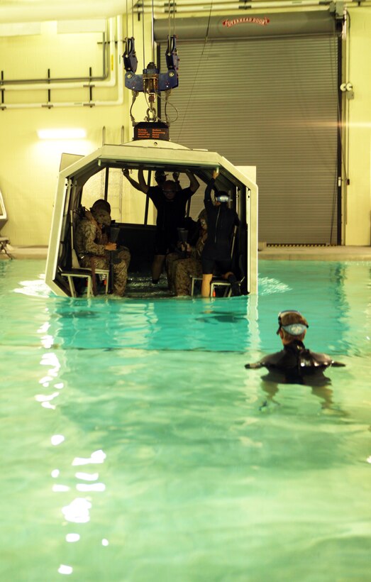 An instructor with the Water Survivor Training Facilities watches as Marines with Combat Logistics Regiment 2, 2nd Marine Logistics Group, prepare to be submerged in water during a Modular Amphibious Egress Trainer exercise aboard Camp Lejeune, N.C., Nov. 9, 2010. As the helo is submerged under water, a group of six Marines or sailors inside make their way out of the helicopter through one of the unlocked hatches located throughout the simulated aircraft.    (U.S. Marine Corps photo by Pfc. Franklin E. Mercado)