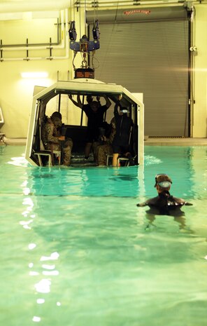 An instructor with the Water Survivor Training Facilities watches as Marines with Combat Logistics Regiment 2, 2nd Marine Logistics Group, prepare to be submerged in water during a Modular Amphibious Egress Trainer exercise aboard Camp Lejeune, N.C., Nov. 9, 2010. As the helo is submerged under water, a group of six Marines or sailors inside make their way out of the helicopter through one of the unlocked hatches located throughout the simulated aircraft.    (U.S. Marine Corps photo by Pfc. Franklin E. Mercado)