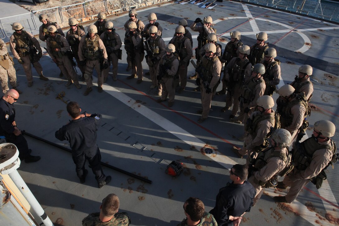 An instructor from the NATO Maritime Interception Operations Training Center (NMIOTC) gives a class on the caving ladder and the telescopic pole to Marines of 26th Marine Expeditionary Unit?s Maritime Interception Operations assault force aboard HNS Aris at Souda Bay, Crete, Greece, Nov. 9, 2010. The MIO assault force went through a one-week course at the NATO Maritime Interception Operations Training Center in tactics to board a suspect vessel.