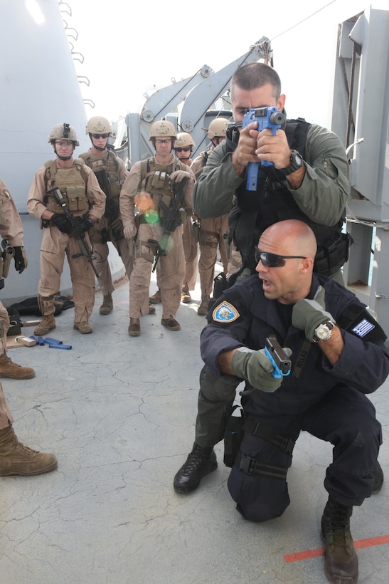 Greek Warrant Officer Alexander Tsaltas, an instructor at the NATO Maritime Interception Operations Training Center (NMIOTC), demonstrates tactical sweep techniques to Marines of 26th Marine Expeditionary Unit's Maritime Interception Operations assault force aboard HNS Aris at Souda Bay, Crete, Greece, Nov. 9, 2010. 26th MEU is currently embarked aboard the ships of Kearsarge Amphibious Ready Group and conducting training in the 5th Fleet area of responsibility.