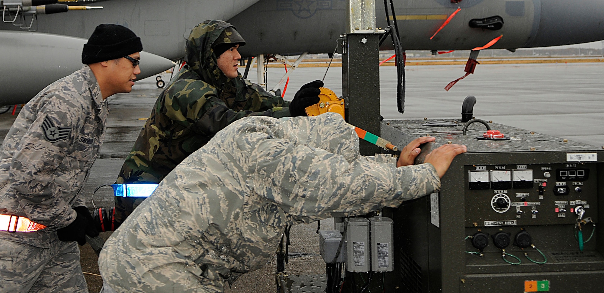 Staff Sgt. Somchay Saynourath and Senior Airmen Daniel Liderbach and Richard Casareza, all crew chiefs with the 44th Fighter Squadron, push a security light into position on the flightline at Chitose Air Base, Japan, Nov. 9. Nearly 200 Airmen from Kadena are deployed for a 2-week Aviation Training Location. The ATR allows for bilateral training with the Japan Air Self Defense Forces for the common defense of Japan while reducing aircraft noise in Okinawa. (U.S. Air Force photo/Tech. Sgt. Mike Tateishi)