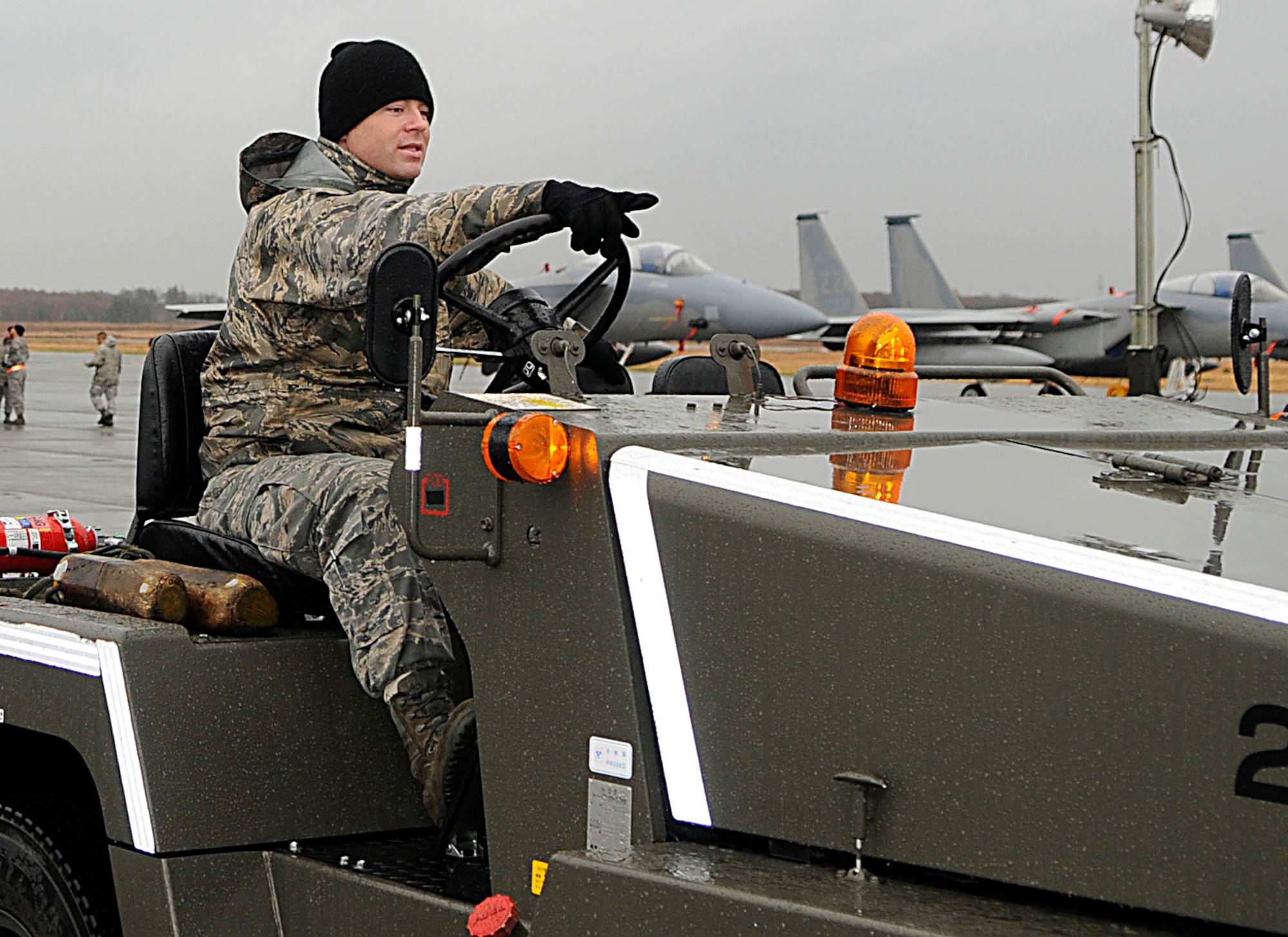 Staff Sgt. Chris Sperry, a crew chief with the 44th Fighter Squadron, points to where he plans to take the F-15 he’s toeing on the flightline at Chitose Air Base, Japan, Nov. 9.  Nearly 200 Airmen from Kadena are deployed for a 2-week Aviation Training Location. The ATR allows for bilateral training with the Japan Air Self Defense Forces for the common defense of Japan while reducing aircraft noise in Okinawa. (U.S. Air Force photo/Tech. Sgt. Mike Tateishi)