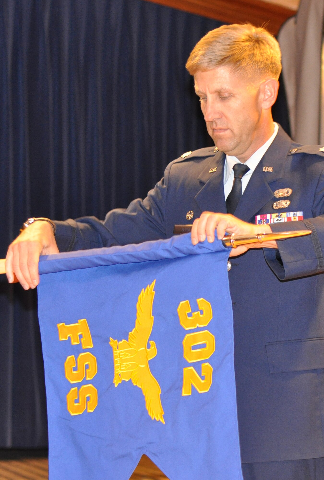 Air Force Reserve Lt. Col. Alan Flolo unveils the 302nd Force Support Squadron guidon during a Nov. 6 ceremony recognizing the squadron's activation at Peterson Air Force Base, Colo. Both the 302nd Services and Mission Support Flights were inactivated officially Oct. 15, giving way to the activation of the 302nd FSS. The new squadron consolidates 15 sub organizations into four, and creates new flights that include force development, manpower and personnel, Airman and family services and sustainment services. Colonel Flolo commands the newly-activated 302nd FSS. (U.S. Air Force photo/Staff Sgt. Stephen J. Collier)