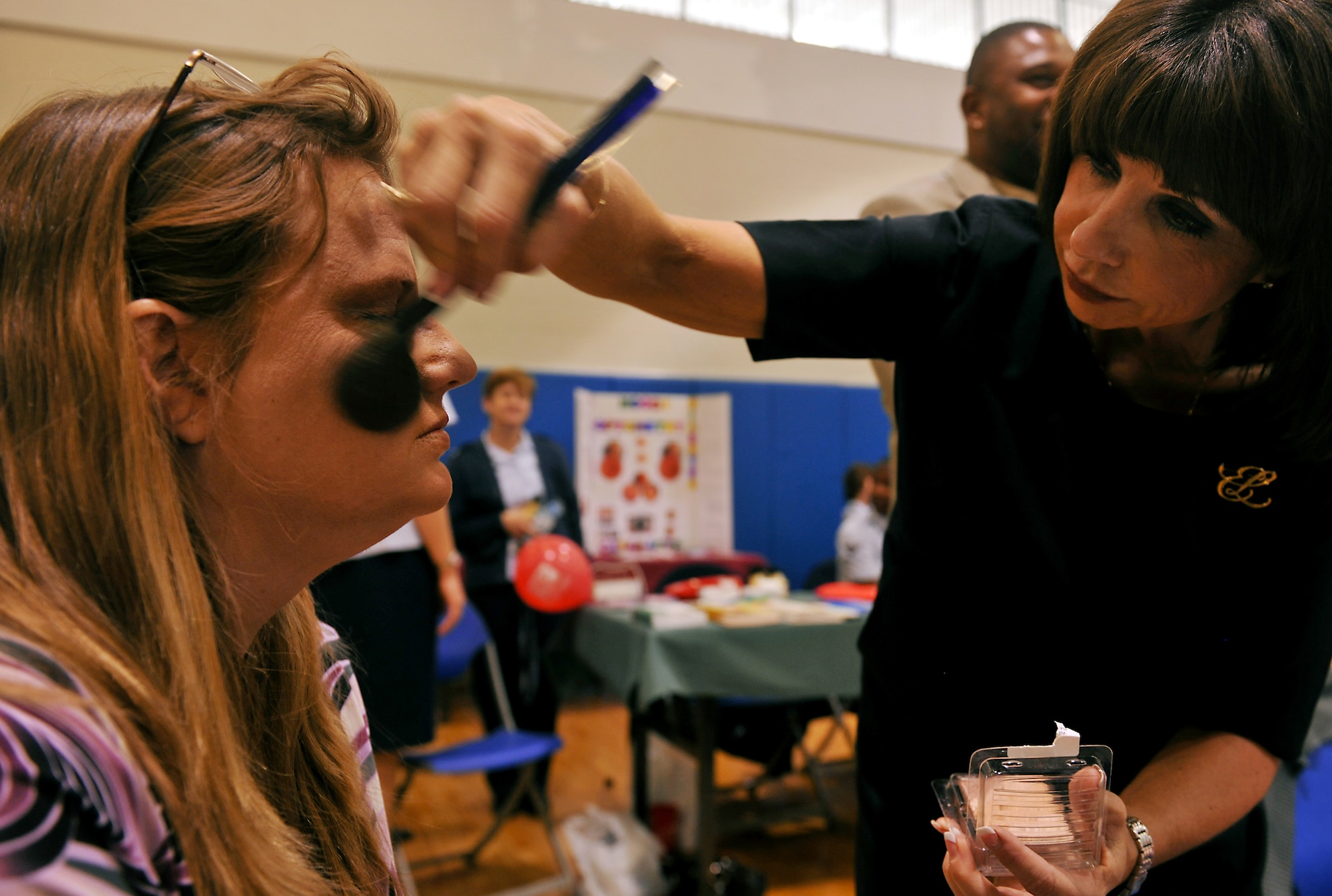 MOODY AIR FORCE BASE, Ga. -- Debbie Marrone, Base Exchange makeup consultant, applies blush to the face of Loretta Hendricks, wife of retired Tech. Sgt. Douglas Hendricks, during Retiree Appreciation Week here Nov. 6.  In celebration of RAW, Moody hosted several events, culminating on Nov. 6 with health briefings, flu shots, ID card renewals and static displays.
(U.S. Air Force photo/Airman 1st Class Joshua Green)(RELEASED)
