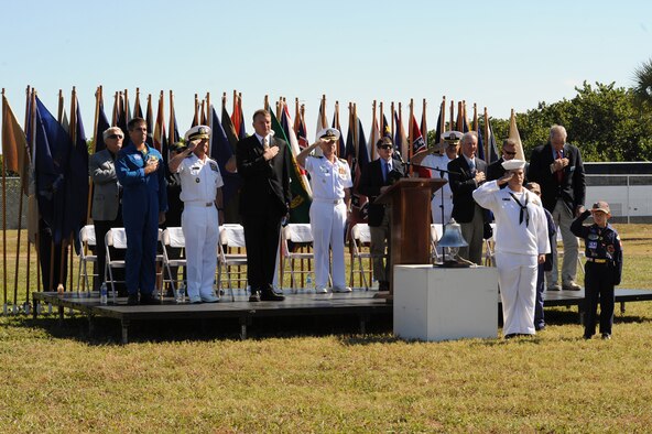 FT. PIERCE, Fla - The 920th Rescue Wing from nearby Patrick Air Force Base made a special appearance overhead to drop off the Navy's official parachute team, the Leap Frogs, at the UDT-SEAL Museum here Fla., Nov. 6, for the museum's 25th annual muster. (Front row, left to right) Astronaut and Navy SEAL commander Chris Cassidy; Adm. Eric T. Olson, commander, U.S. Special Operations Command; U.S. Rep. Thomas J. Rooney of Florida; retired Navy Capt. Robert Bedingfield, UDT-SEAL Museum chaplain; retired Navy Capt. Michael R. Howard (SEAL), UDT-SEAL Museum executive director; retired Navy Lt. Thomas Norris (SEAL), Medal of Honor recipient; David F. Godshall, UDT-SEAL Museum board of directors vice president; and Willard B. Snyder, UDT-SEAL Museum board of directors president, recite the pledge of allegiance at the opening ceremony of the event (Photo/Senior Airman Anna-Marie Wyant). 
