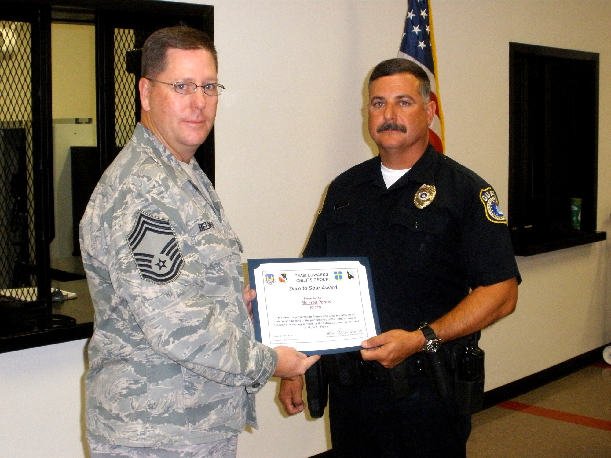Mr. Fred Porras, a civilian security officer assigned to the 95th Security Forces Squadron, is presented the 'Dare to Soar' award, Nov. 2, from the Edwards' Chiefs Group president, Chief Master Sgt. Michael B. Belanger, 412th Maintenance Group Superintendent. The award is reserved for military and civilian members who are recognized for doing above and beyond their required duties.  (Official Air Force photograph)