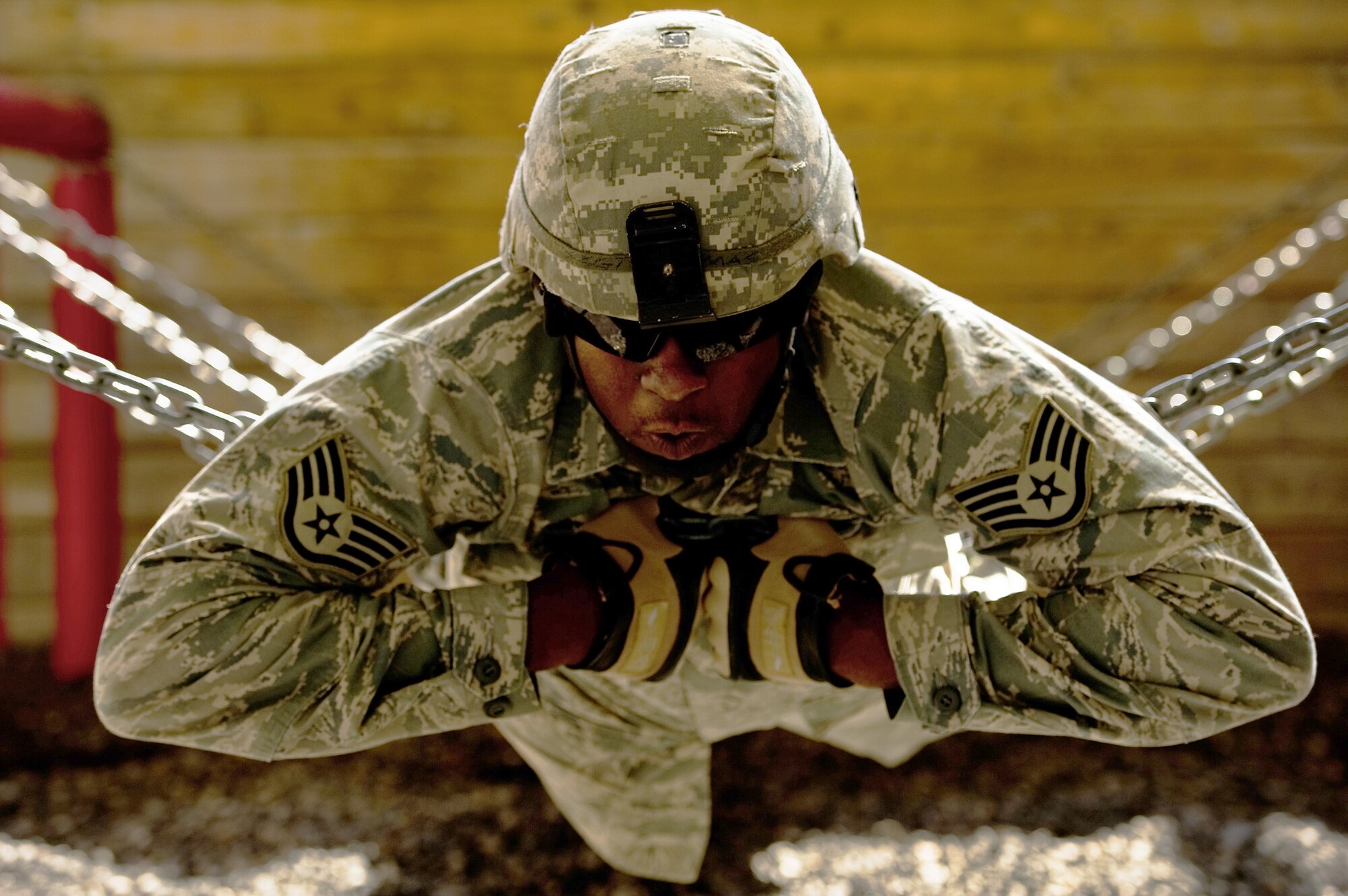 Staff Sgt. Marcus Thomas holds onto a chain which creates a human bridge helping him and his team complete an obstacle Oct. 22, 2010, at Camp Bullis, Texas during the Combat Leadership Course. (U.S. Air Force photo/Staff Sgt. Jonathan Snyder)
