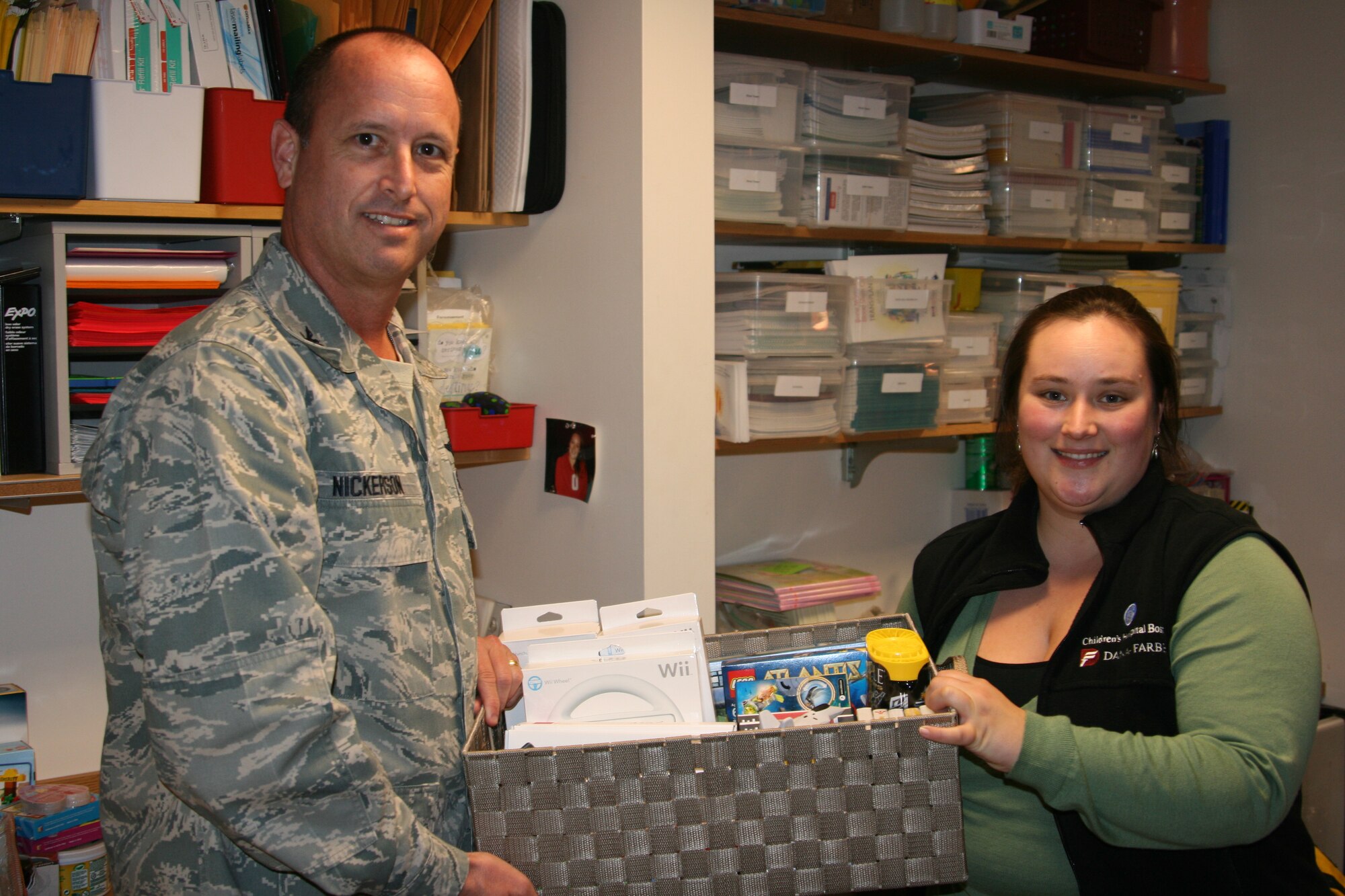 Col. Timothy Nickerson, Aerospace Management Systems Division deputy chief, presents a donation of portable media players, video game controllers and video games to Martha Young, Children's Hospital Boston Cancer Center patient and family education specialist Nov. 3 at the hospital. (Courtesy photo) 
