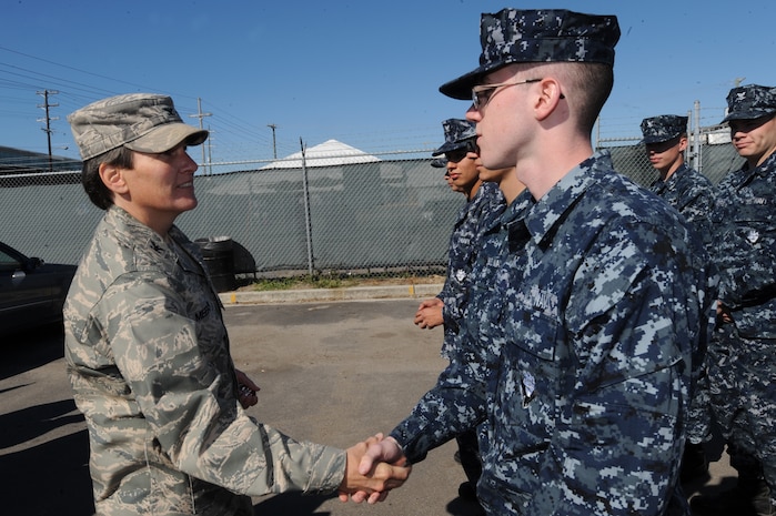 Col. Martha Meeker gives a Commander's Coin to Electricians Mate 3rd Class John Asija, thanking him for his participation in the local Veterans Day parade Nov. 7, 2010, in downtown Charleston, S.C. Colonel Meeker is the Joint Base Charleston Commander and Electrician's Mate Asija is attached to the Department of Transient Personnel, Naval Support Activity Charleston. (U.S. Air Force photo/James M. Bowman)(released)