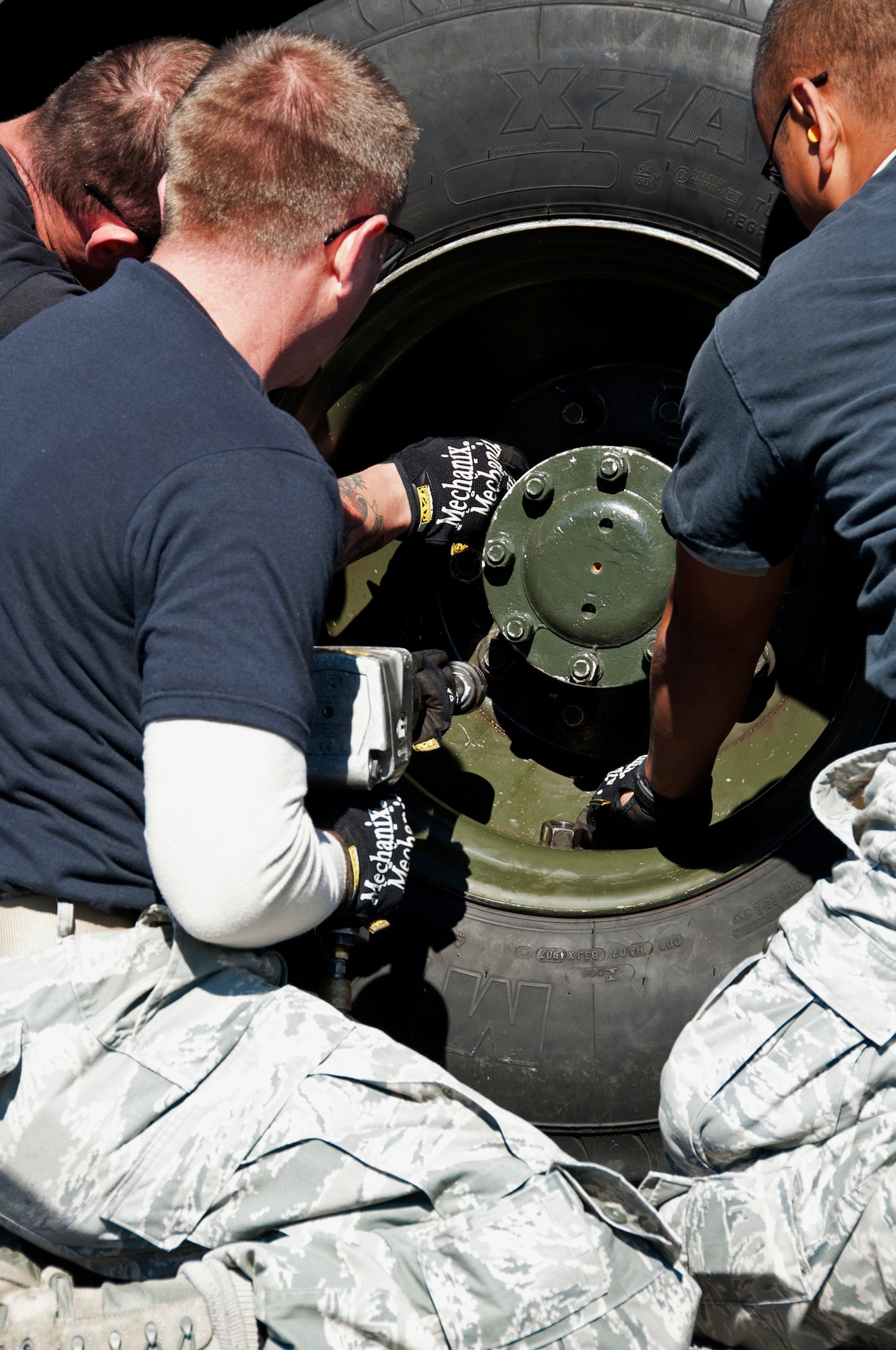 Hurlburt Field’s 1st Special Operations Logistics Readiness Squadron’s “men in black” tighten down lug nuts during the tire change portion at the first-ever Eglin/Hurlburt Field LRS competition Nov. 5.  Hurlburt’s “Team A” won the overall competition almost five minutes.  The “best-time” competition included pallet building, obstacle courses and tire changing.  (U.S. Air Force photo/ Samuel King Jr.)