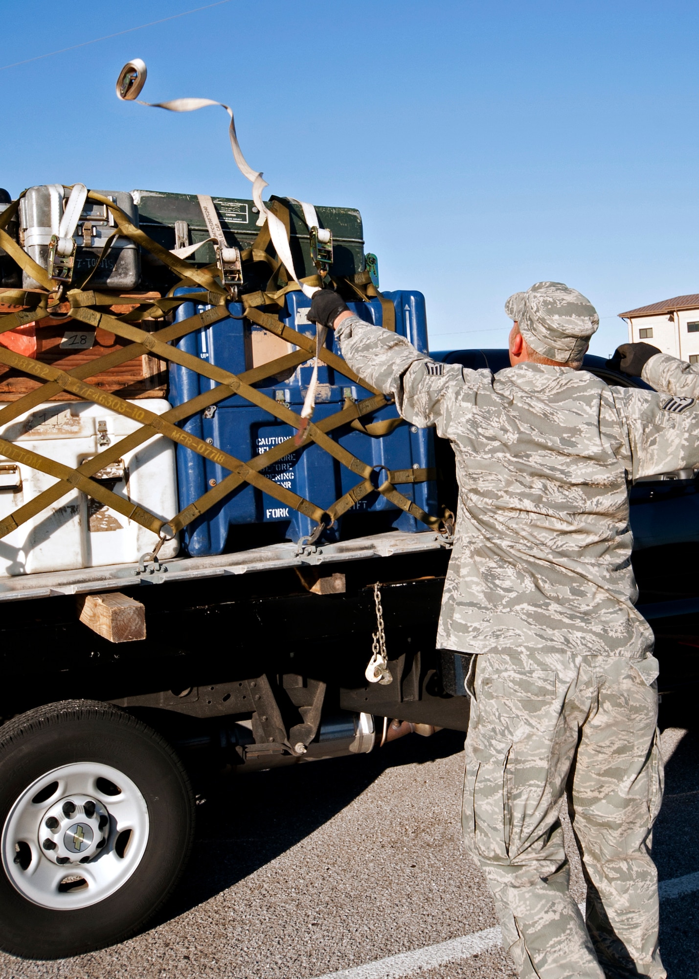 A 96th Logistics Readiness Squadron member sends a tie-down strap across the top of a pallet during the pallet loading portion at the first-ever Eglin/Hurlburt Field LRS competition Nov. 5.  Hurlburt’s “Team A” won the overall competition almost five minutes.  The “best-time” competition included pallet building, obstacle courses and tire changing.  (U.S. Air Force photo/ Samuel King Jr.)