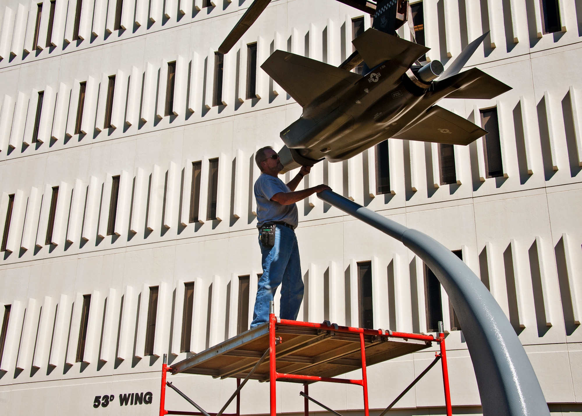 Robert Owens, 796th Civil Engineer Squadron, brings the new F-35 Lightning II static display into place in front of the 53rd Wing building Nov. 3.  The static display compliments the F-22 display on the left side of the entrance.  The 53rd Wing will be responsible for the operational testing of the F-35 aircraft.  (Air Force photo/ Samuel King Jr.)