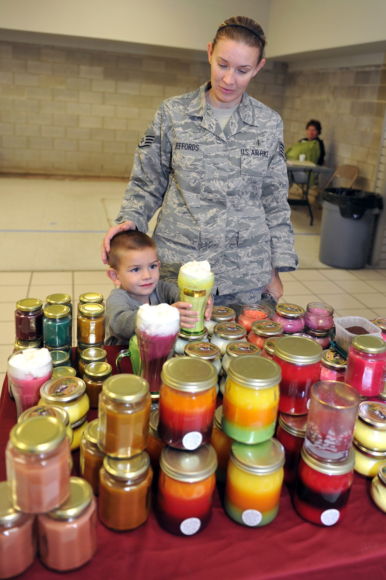 Staff Sgt. Julie Jeffords, 19th Medical Diagnostics Squadron ultra sound tech, and her 3-year-old son, Tucker, check out some scented candles Nov. 5 at The Country Creek Candles vendor at the Spouses Club Holiday Bazaar. Many local vendors participated in the bazaar located at the old base exchange. (U.S. Air Force photo by Staff Sgt. Chris Willis)
