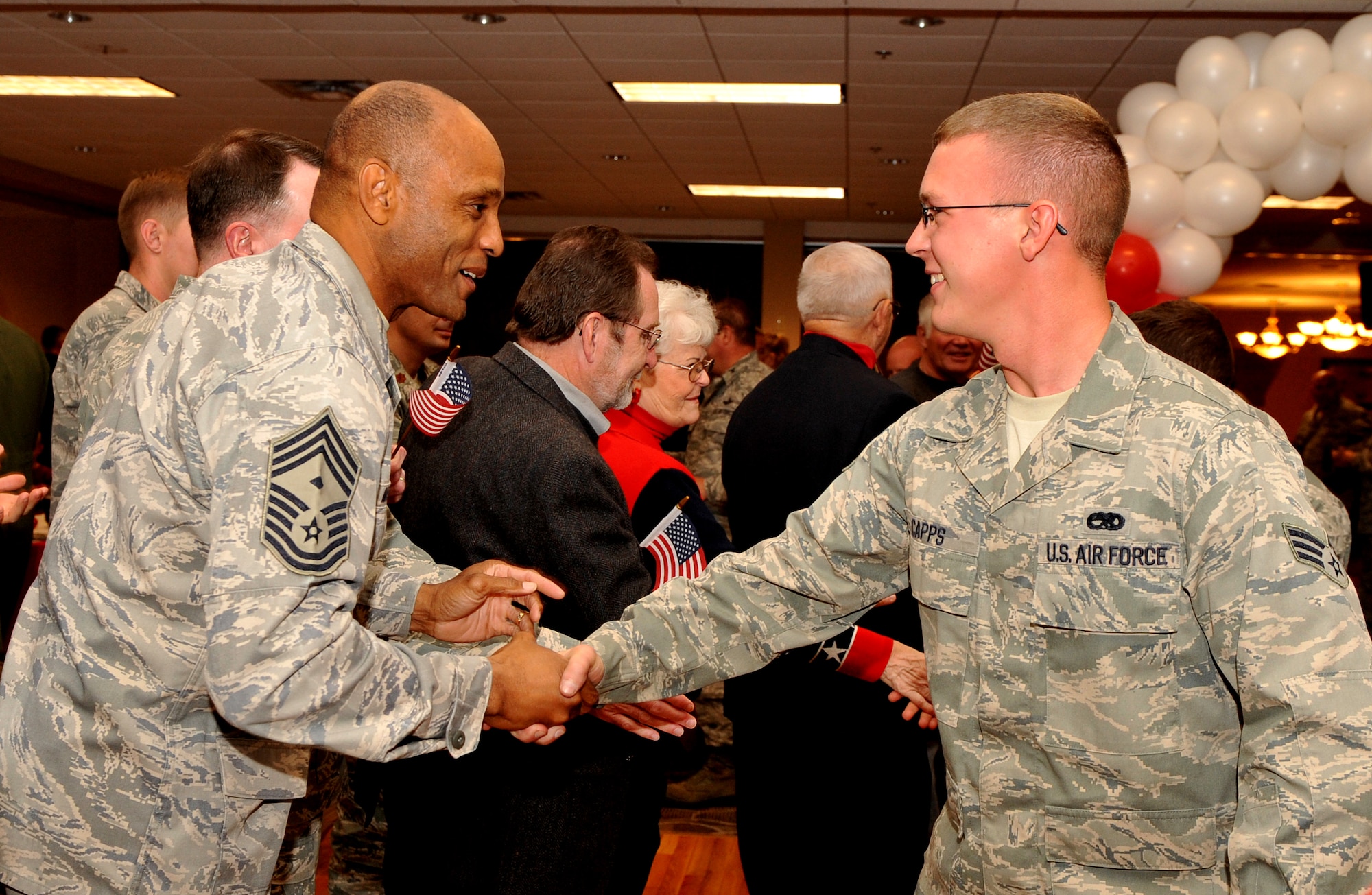 Chief Master Sgt. Frankie McGriff, 19th Equipment Maintenance Squadron first sergeant, shakes hands with Senior Airman Preston Capps, 19th EMS aerospace ground equipment journeyman, during a Welcome Home Warriors homecoming Nov. 5. The event is designed to recognize individual deployers who return home individually or in small groups not part of a large group. (U.S. Air Force photo by Senior Airman Gul Crockett)