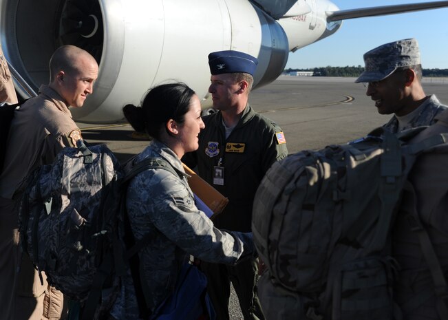 Col. John Wood and Chief Master Sgt. Terrance Greene shake the hands of returning Airmen as they exit the aircraft Nov. 7, 2010 on Joint Base Charleston, S.C. During their deployment to the Middle East, the 15th Airlift Squadron provided immediate support to flood ravaged Pakistan; delivering more than 2.5 million pounds of aid while countinuing the non-stop support of missions downrange. Colonel Wood is the commander for the 437 Airlift Wing and Chief Greene is the command chief for the 437th AW. (U.S. Air Force photo/Senior Airman Timothy Taylor)