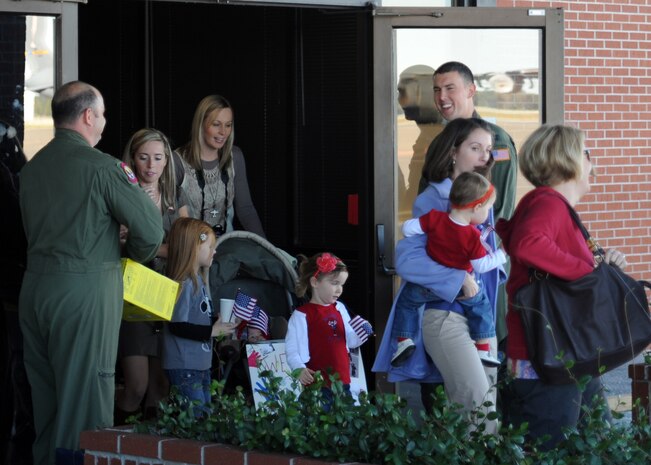 Family and friends exit the back of the passenger terminal to wait on the flightline to greet the Airmen of the 15th Airlift Squadron who returned home to Charelston after a four-month deployment to the Middle East Nov. 7, 2010 on Joint Base Charleston, S.C. (U.S. Air Force photo/Senior Airman Timothy Taylor)