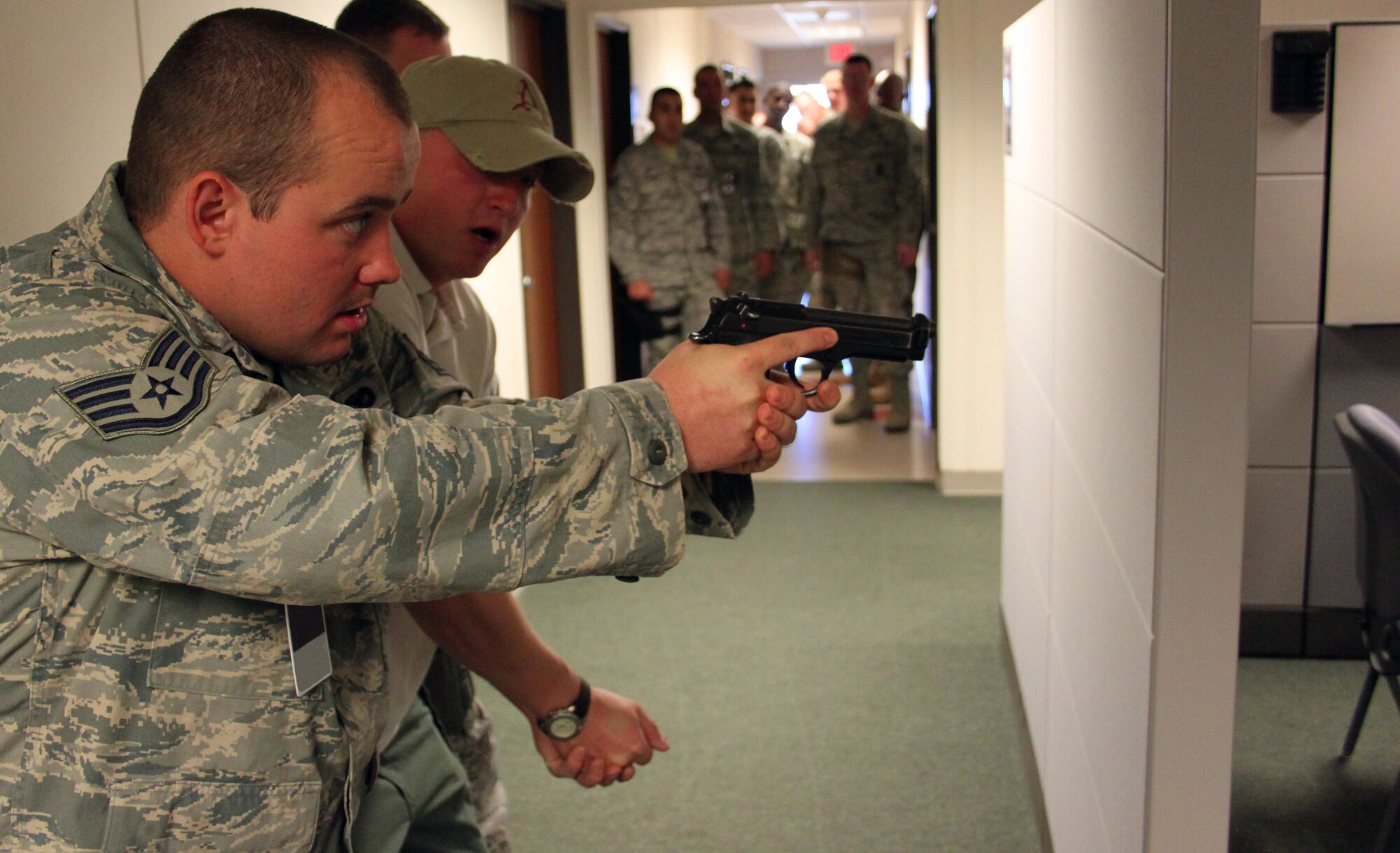 Staff Sgt. Joshua Willms, left, takes instruction in active shooter training from Shawn O'Reilly, a Department of the Army Law Enforcement Officer from Fort Carson, Colo., on Nov. 7 at the 310th Space Wing Headquarters. O'Reilly worked with the members of the 310th Security Forces Squadron on two-man and three-man active shooter scenarios during the unit training assembly. (U.S. Air Force photo/Tech. Sgt. Scott P. Farley)