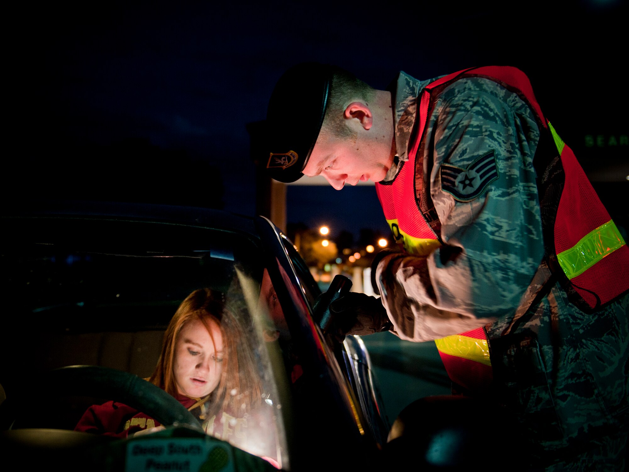 MOODY AIR FORCE BASE, Ga. -- Staff Sgt. David Newman, 23rd Security Forces flight chief, asks a passenger for driver's information during a sobriety check Nov. 5. The 23rd SFS conducted checks to help keep the roads safe and to let the community know Moody takes alcohol-related incidents seriously. (U.S. Air Force photo/Senior Airman Jamal D. Sutter)(RELEASED)