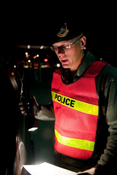 MOODY AIR FORCE BASE, Ga. -- Airman 1st Class Jeremy Vess, 23rd Security Forces Squadron patrolman, reads a precautionary brief during a sobriety check Nov. 5. Security forces personnel read the brief to inform passengers on reasons for the check and things to be aware of during the procedure. (U.S. Air Force photo/Senior Airman Jamal D. Sutter)(RELEASED)