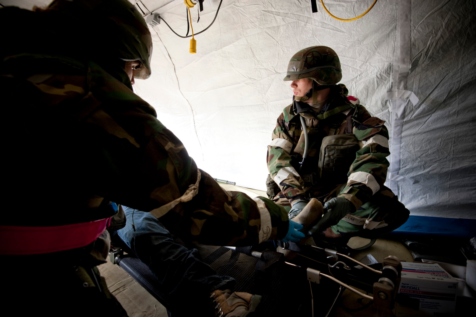 U.S. Air Force Senior Airman Benjamin Smith (right), 35th Aerospace Medical Squadron medic, and Tech. Sgt. Tanya Jacquez, 14th Fighter Squadron medic, apply a Hare traction splint to a volunteer roleplayer, Airman 1st Class Perez, Alejandro during an operational readiness exercise at Misawa Air Base, Japan, Nov. 9, 2010. The medical teams operated out of tents to simulate the challenges of treating patients in a deployed environment. (U.S. Air Force photo by Staff Sgt. Samuel Morse/Released)