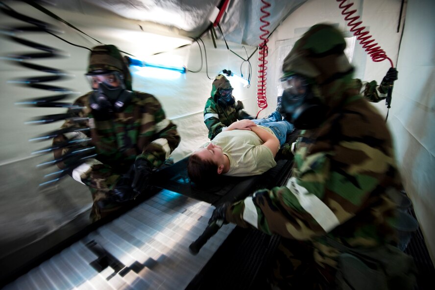 Medics from the 35th Medical Group demonstrate proper patient decontamination procedures in a simulated deployed environment during an operational readiness exercise at Misawa Air Base, Japan, Nov. 9, 2010. The decontamination team kept the exercise as real as possible, short of drenching their volunteer patient with water and cleaning solution. (U.S. Air Force photo by Staff Sgt. Samuel Morse/Released)
