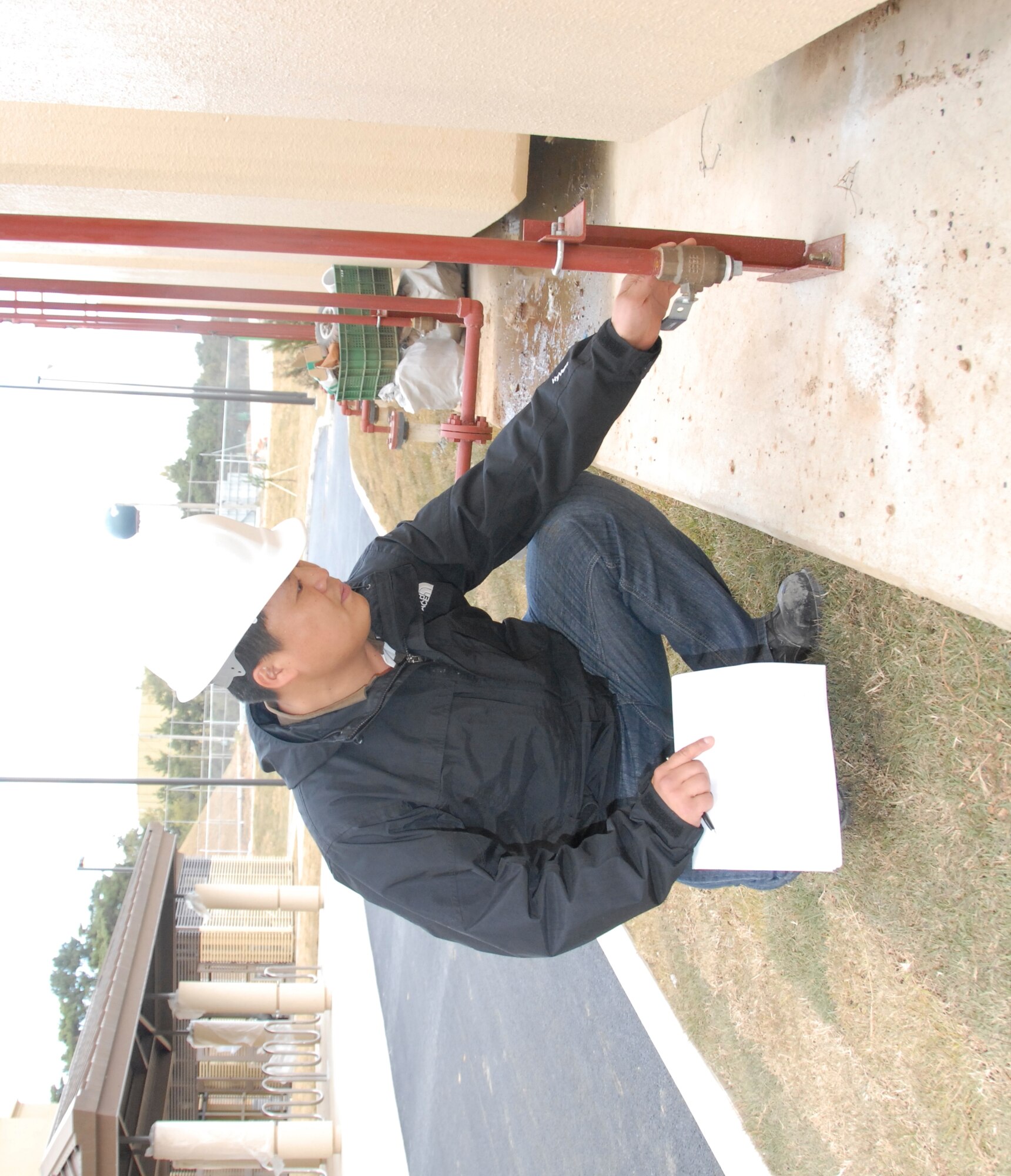 KUNSAN AIR BASE, Republic of Korea -- Kim Yong-Sik, 8th CES construction inspector, checks the line to a fuel tank for a new dormitory building under construction here. Mr. Kim was recently named the 2010 U.S. Forces Korea Technician of the Year for the annual USFK Civilian Employee of the Year awards. (U.S. Air Force photo/Staff Sgt. Amanda Savannah)