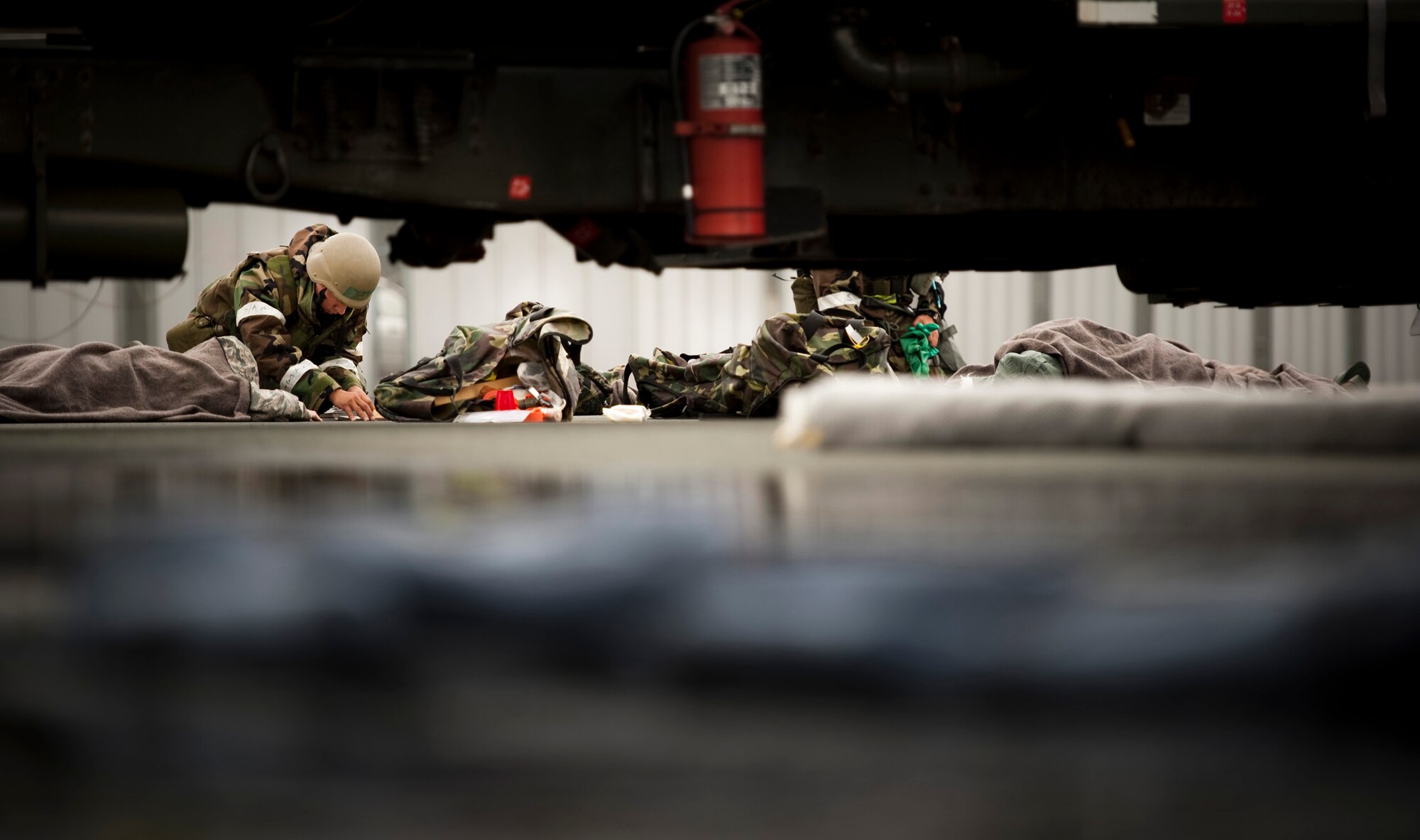 U.S. Air Force Tech. Sgt. Quentin Sanchez, 35th Logistics Readiness Squadron fuels distribution supervisor, tends to simulated accident victims during an operational readiness exercise at Misawa Air Base, Japan, Nov. 9, 2010. The scenario created by the exercise evaluation team involved an R-11 Refueler hit by a simulated attack, leaking JP-8 fuel, pinning the driver and injuring bystanders. (U.S. Air Force photo by Staff Sgt. Samuel Morse/Released)