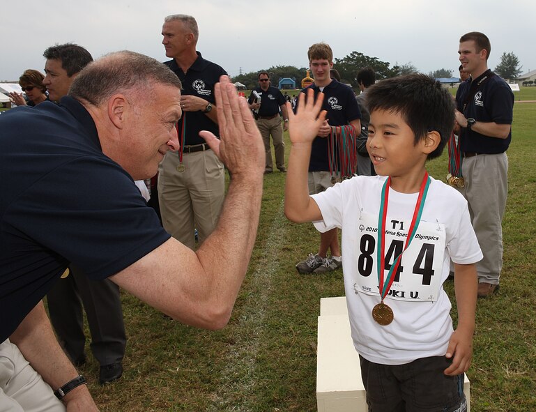 Pacific Air Forces Commander Gen. Gary North high-fives a young Okinawan athlete during the Kadena Special Olympics Nov. 6. General North said the games have always been a way to bring people from opposite sides of the world together to support the athletes, their caretakers and a noble cause. (Courtesy photo by Chip Steitz)