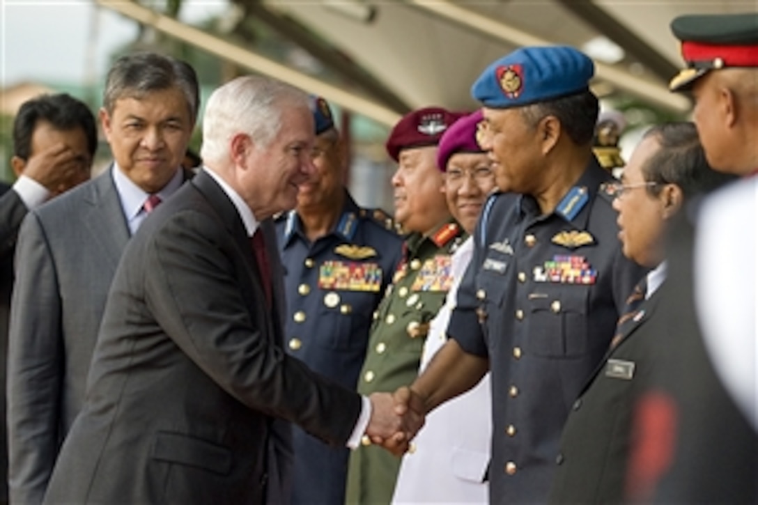 Secretary of Defense Robert M. Gates shakes hands with Defense officials as he leaves the Defense Ministry building in Kuala Lumpur, Malaysia, on Nov. 9, 2010.  
