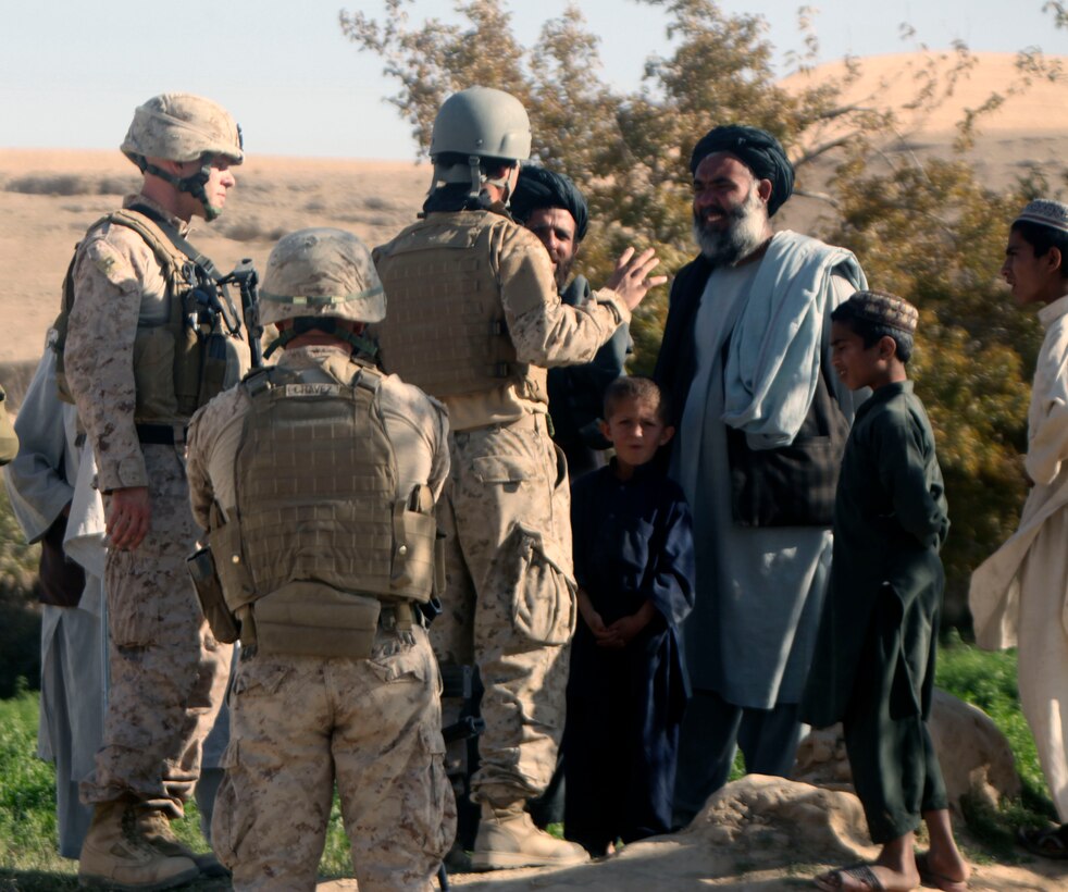 Marines from 9th Engineer Support Battalion, 1st Marine Logistics Group (Forward), talk to a local Afghans about demolishing a wall while Marines conduct road improvement operations adjacent to the wall in Sangin, Helmand province, Afghanistan. The Marines of 9th ESB, 1st MLG (FWD), improved roads near Sangin in order to provide a smoother and safer means of transportation for both coalition forces and Afghan villagers.